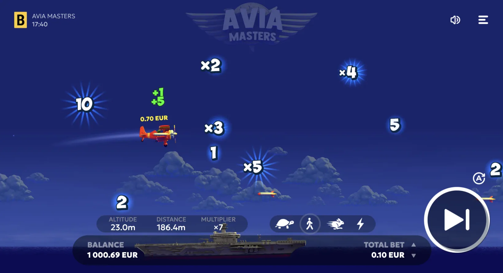 Aviamasters flight in progress: the red biplane collecting a +1 and +5 pickup, with x2, x3, x4 and x5 multipliers and a rocket scattered across the night sky above the carrier